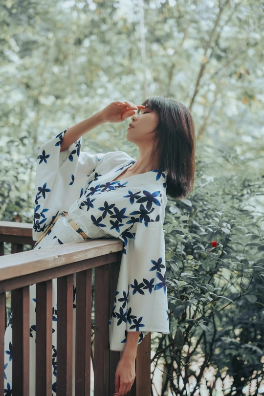 一个穿着碎花连衣裙的女人站在甲板上