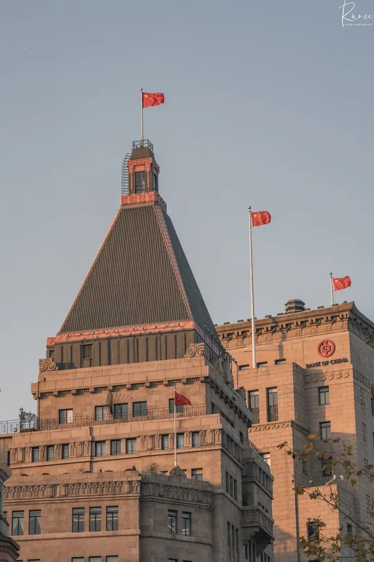 一个有钟楼和旗杆的钟楼 顶部飘扬着国旗