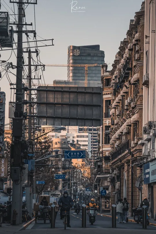 一批人在高楼旁边的一条街道上行走