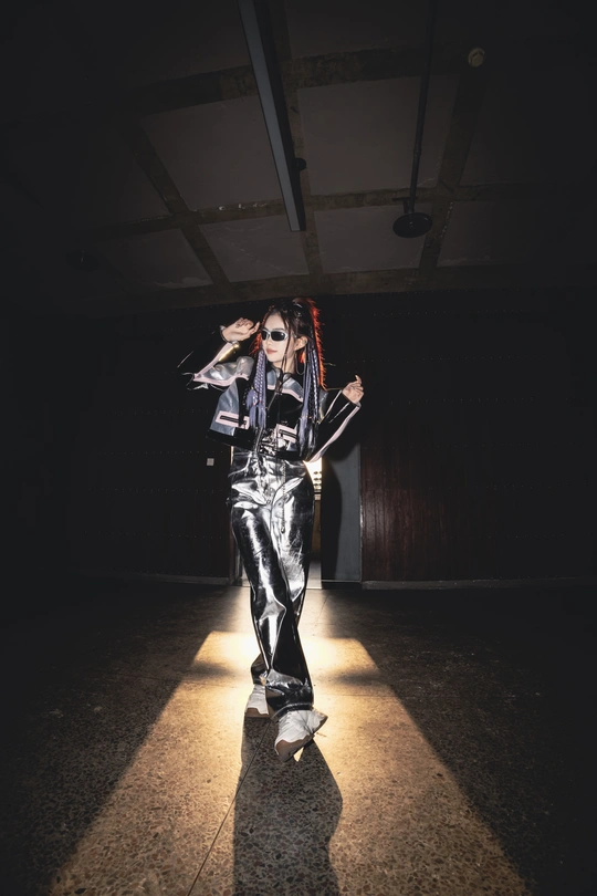 一个穿着黑色和银色衣服的女人穿过一个黑暗的房间