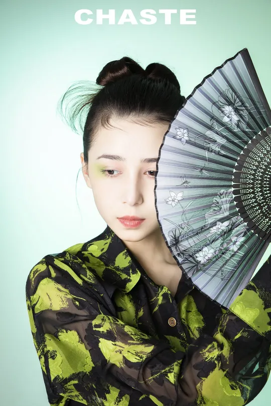 一位穿着和服的女子举着一把伞遮住脸
