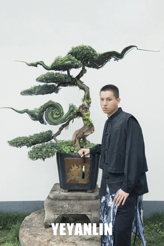 站在一株小植物旁边的一个男人