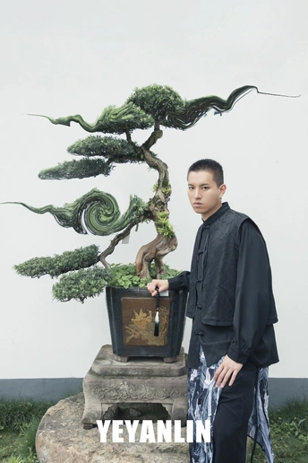 站在一株小植物旁边的一个男人
