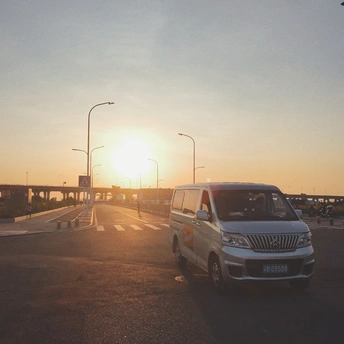 日落时的高速公路 路上有汽车行驶 路边停着一辆白色SUV。