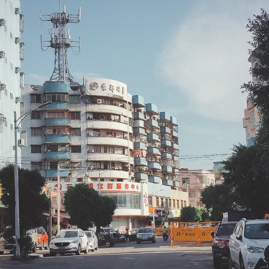 城市中的一条街道 路上有汽车 背景中有一座高楼公寓。