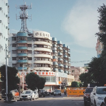 城市中的一条街道 路上有汽车 背景中有一座高楼公寓。