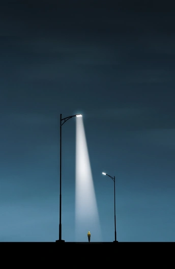 一个男人晚上站在路灯下 天空中有一束明亮的光