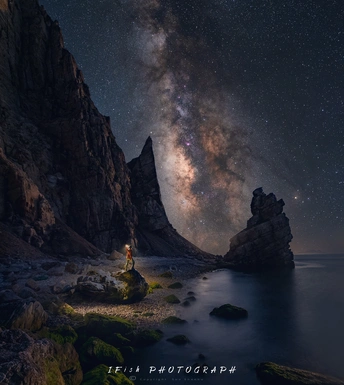 一个人站在海洋上 晚上仰望天空中的星星。