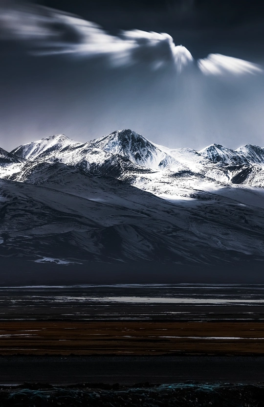 天空中的云后 一座白雪皑皑的山脉