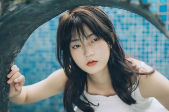 一个年轻女子躲在树后