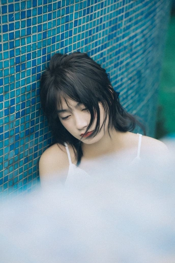 一个年轻女子在蓝墙的游泳池里洗澡