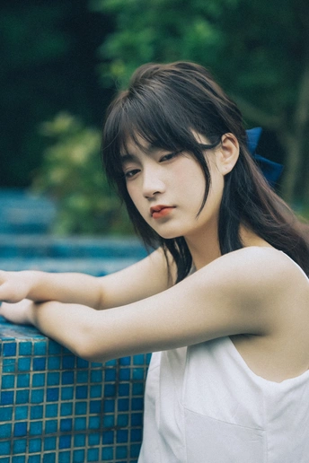 一个坐在外面蓝色墙上的年轻女人