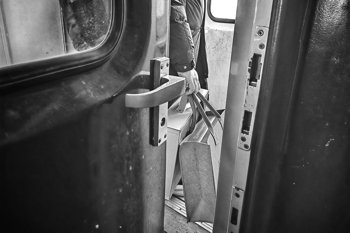 一张黑白照片 男人正在火车窗口向外看。