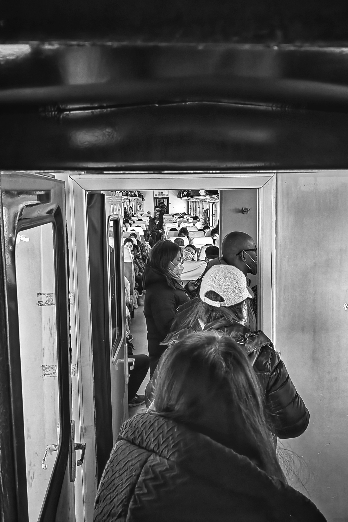 一张黑白照片 人们站在地铁的门口