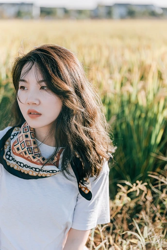 一位年轻女子站在麦田中的人物肖像