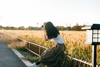 站在公路边 靠近围栏和田野的年轻女子