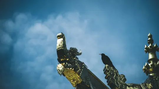 一尊金马雕塑 背景为蔚蓝天空。