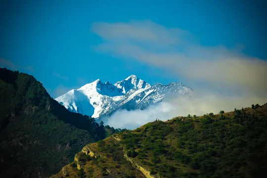远处的雪山 山谷中有山丘和云彩。