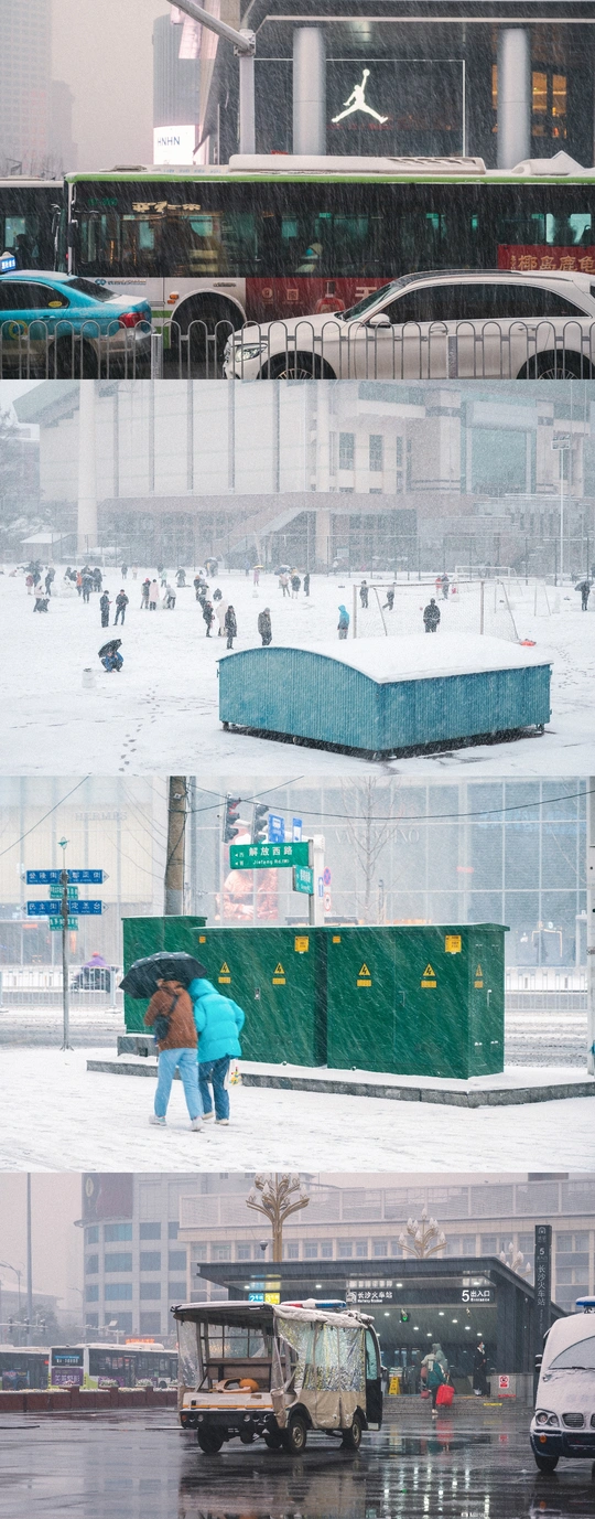 一个雪花飘飘的城市 街上行人络绎不绝 背景中汽车和建筑错落有致 一个人手拿雨伞。