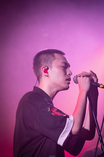 在音乐会的舞台上对着麦克风唱歌的男人