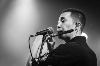 演唱会舞台上一名男子对着麦克风唱歌的黑白图像