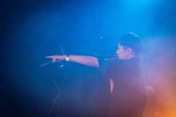 拿着麦克风和乐队在舞台上演奏乐器的人
