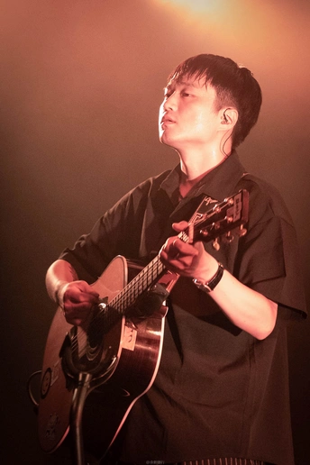 一个年轻人在音乐会舞台上演奏乐器的画面