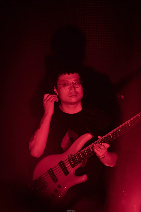 一个戴眼镜的年轻人弹吉他的黑白图像