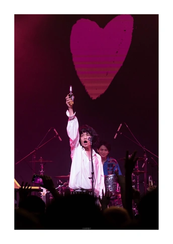 一个男人在舞台上拿着麦克风 乐队在一群人面前表演