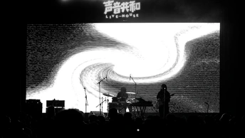 一张黑白图片 展示一个人在音乐会舞台上表演。