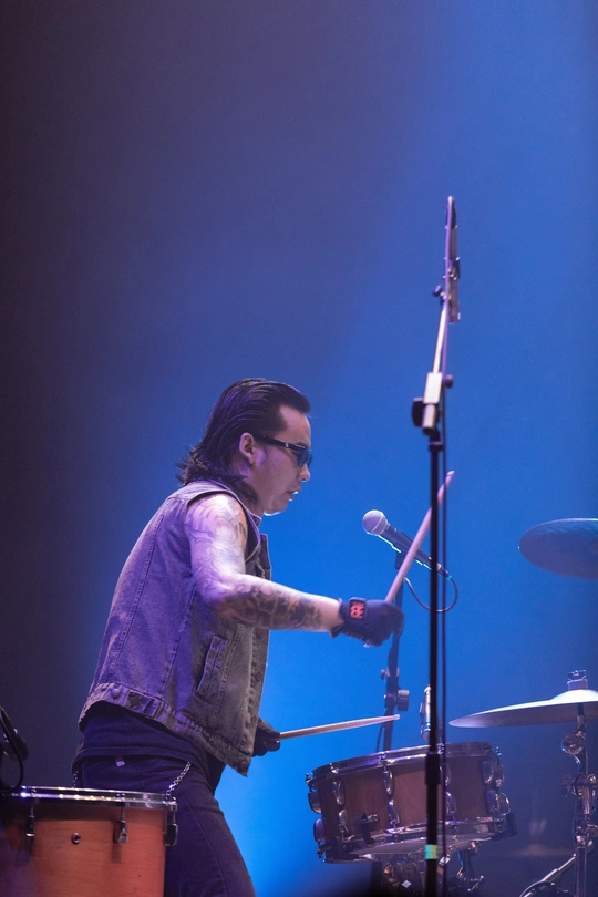 图片可能包含演奏乐器的人 比如鼓手 在舞台上 音乐会和室内。