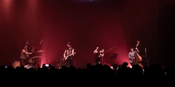 舞台上夜晚演奏乐器的乐队的图像