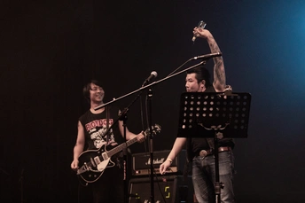 一个夜晚舞台上一个男人在演奏乐器 女人对着麦克风唱歌 乐队在演奏。