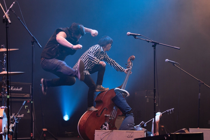 舞台上弹贝斯的一个人在表演一支乐队