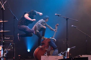 舞台上弹贝斯的一个人在表演一支乐队