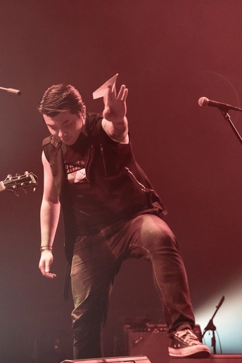 一个人在舞台上 与乐队一起演奏吉他并对着话筒唱歌