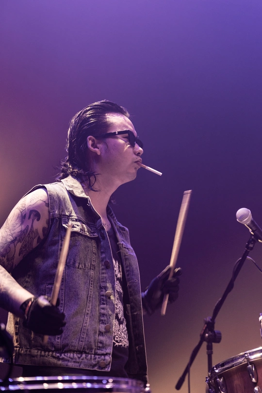 图片可能包含一个人在舞台上弹奏乐器 是鼓手 音乐会 抽烟