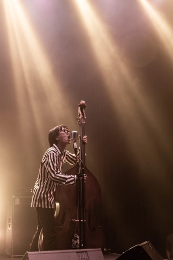 一个在音乐会舞台上演奏乐器的人在灯光下