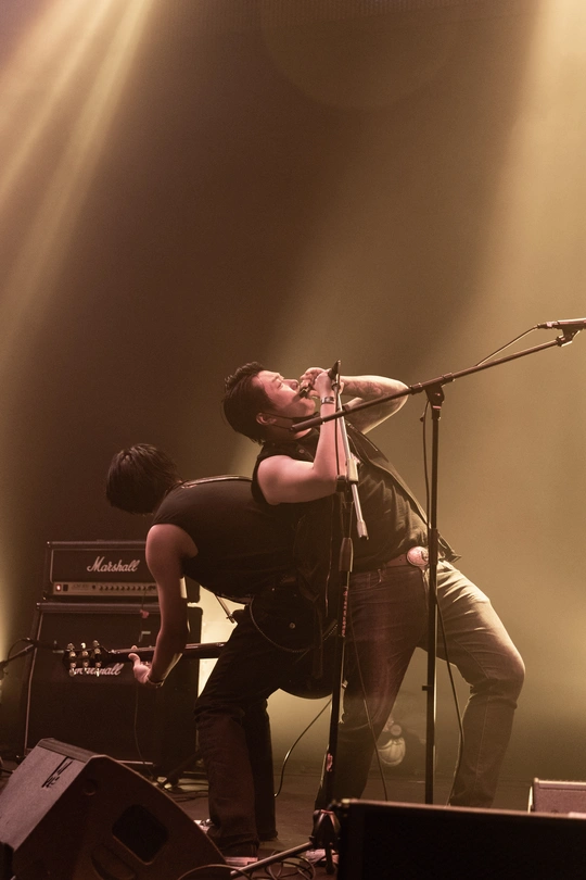 图片可能包含演奏乐器的人、乐队、麦克风和吉他 在舞台上。