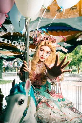 一个穿着裙子的女人骑在一辆马戏团旋转木马上