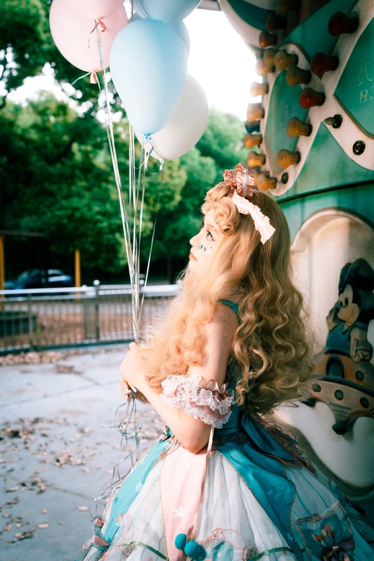 一位穿着蓝色裙子的女士在马戏团前拿着气球