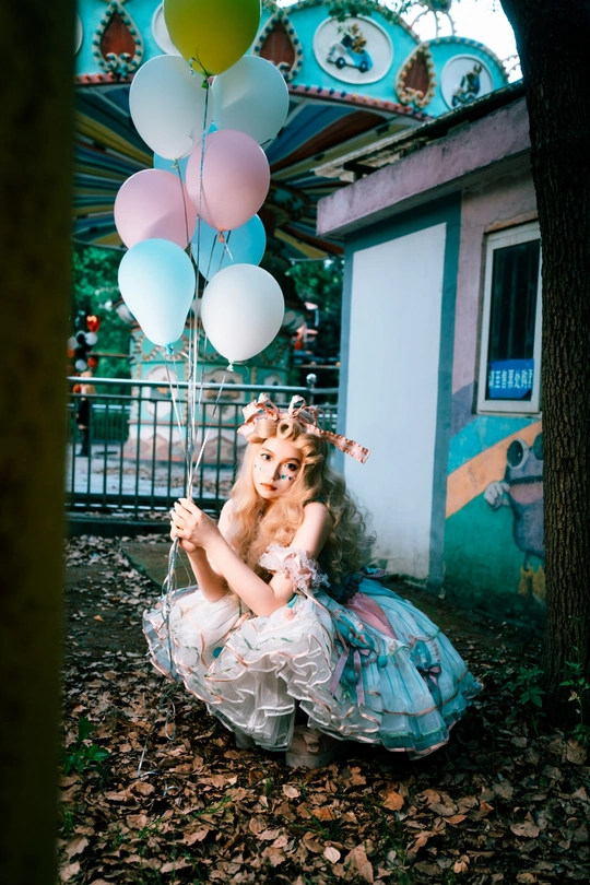 一个穿着连衣裙的小女孩抱着一只小狗