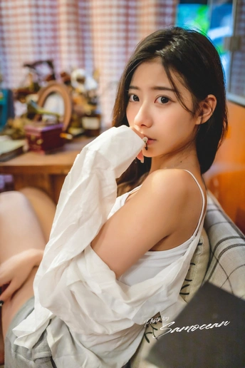 一个穿着白衬衫的年轻女子坐在椅子上
