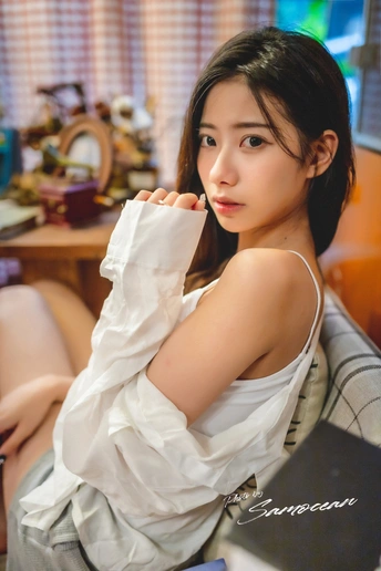 一个穿着白衬衫的年轻女子坐在椅子上