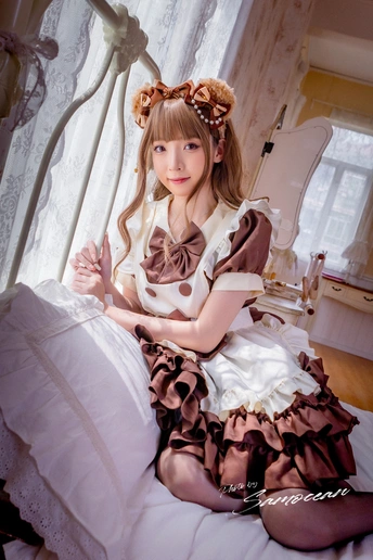 一个小女孩穿着一件白色连衣裙坐在床上