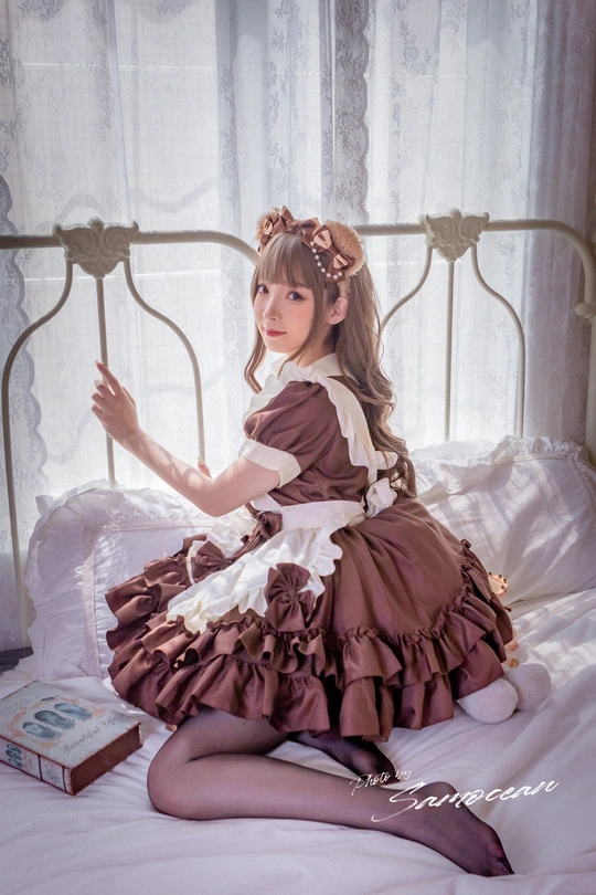 一个小女孩穿着衣服坐在床上