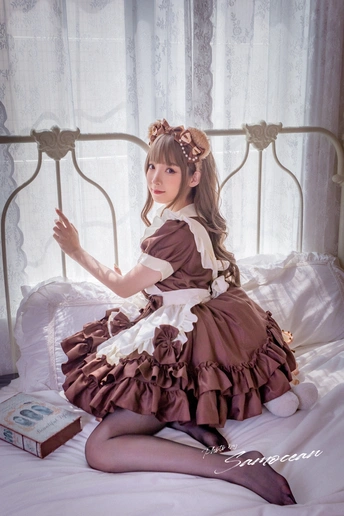 一个小女孩穿着衣服坐在床上