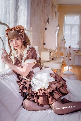 一个穿着连衣裙的年轻女子坐在床上