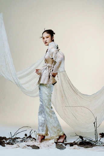 穿着白色连衣裙的模特站在白色背景上