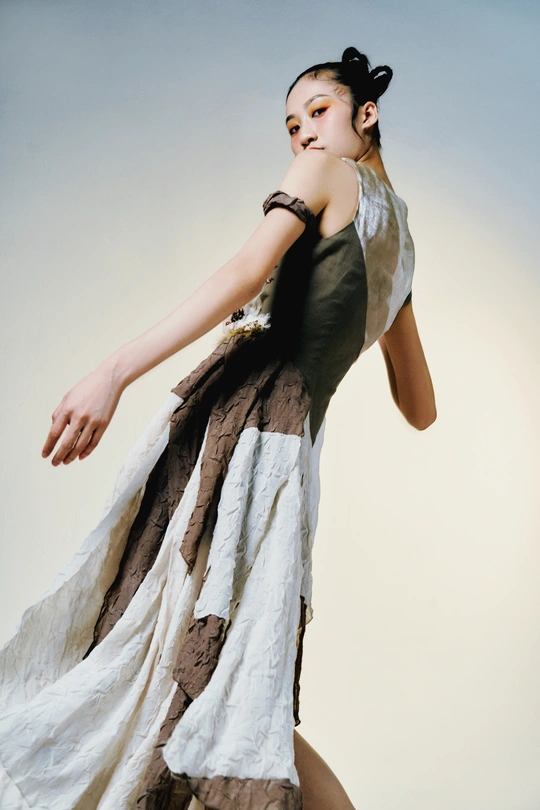 一位身穿白色连衣裙的年轻女子在白色背景下摆姿势